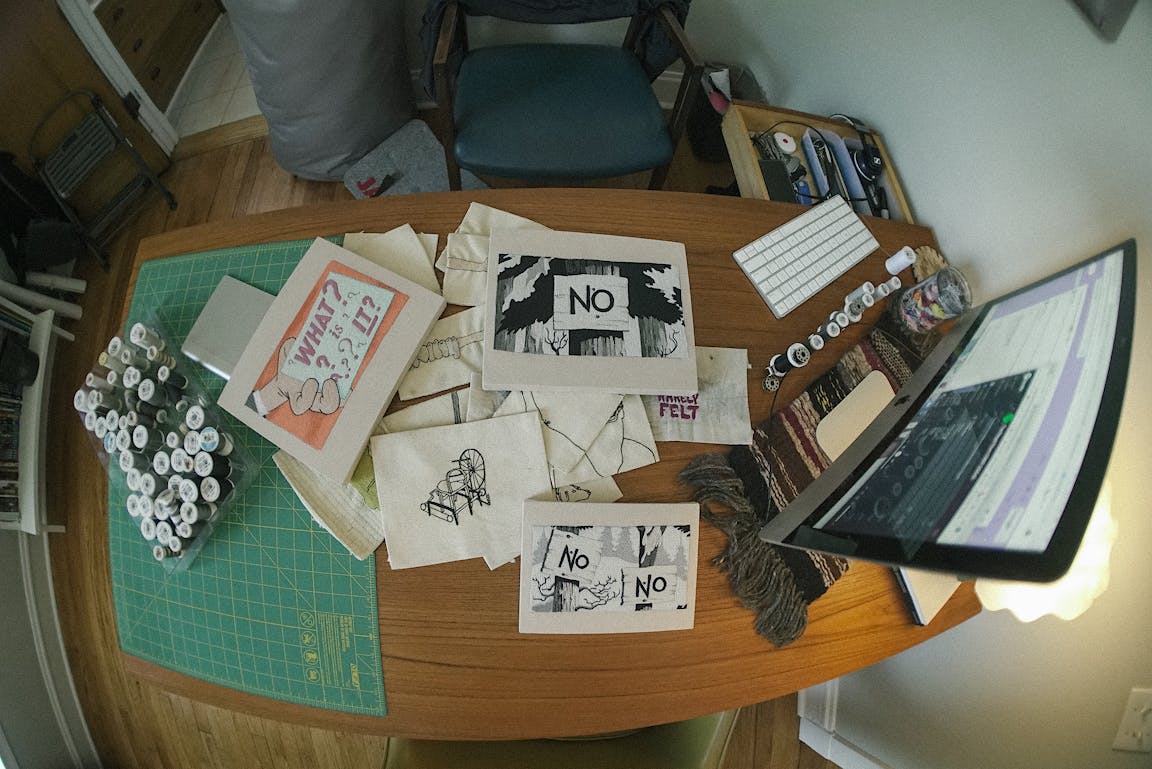 An overhead view of a desk scattered with drawings.
